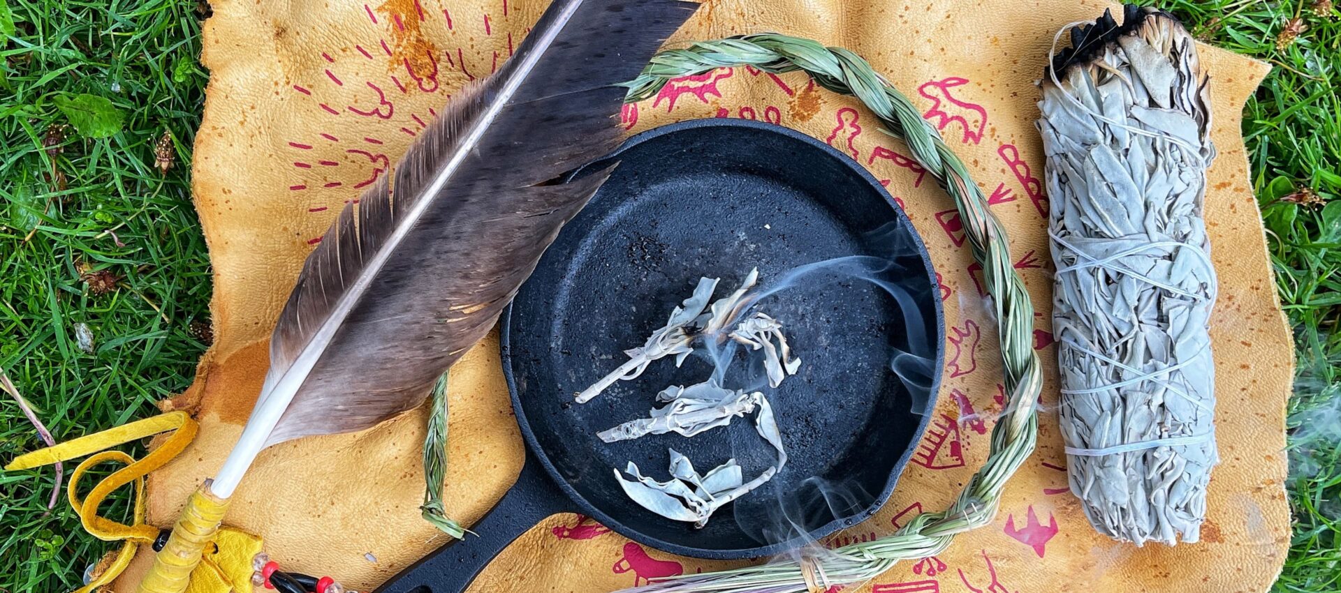 Photo of a feather, a pot with incense placing on a leather skin