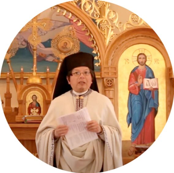 Photo of a priest holding some papers standing in front of an altar