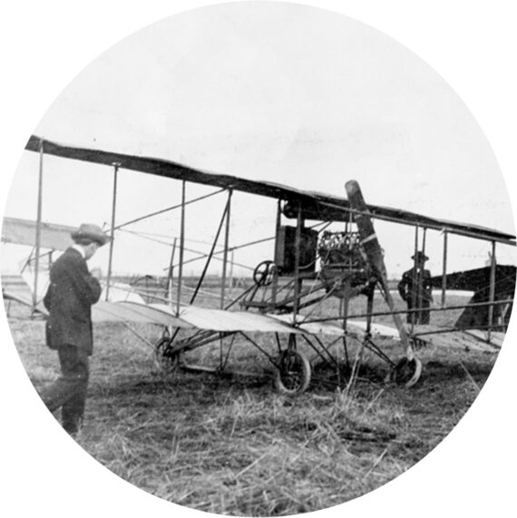 A classic airplane with two men standing next to it